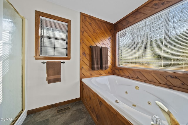 3430 Laurel Ridge Way, Sevierville, TN 37862 - bathroom with stone finish flooring, a tub with jets, wooden walls, plenty of natural light, and a shower stall