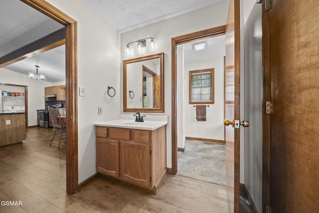 3430 Laurel Ridge Way, Sevierville, TN 37862 - bathroom featuring a chandelier, vanity, wood finished floors, vaulted ceiling, and a textured ceiling