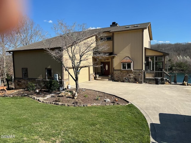 20 Brixton Ln, Crossville, TN 38555 - rear view of house featuring a yard, concrete driveway, stone siding, and a chimney