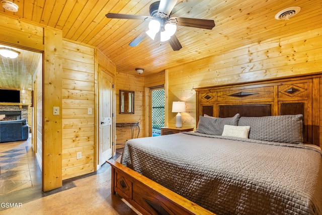 3391 Clear Valley Dr, Sevierville, TN 37862 - bedroom featuring wood walls, wood ceiling, concrete flooring, and a stone fireplace