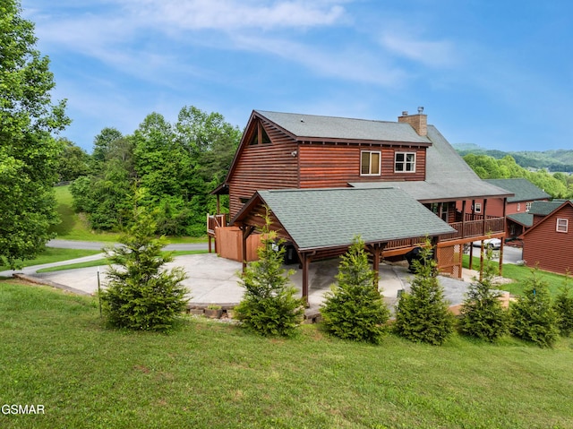 3391 Clear Valley Dr, Sevierville, TN 37862 - rear view of property featuring roof with shingles, a chimney, a yard, and a patio