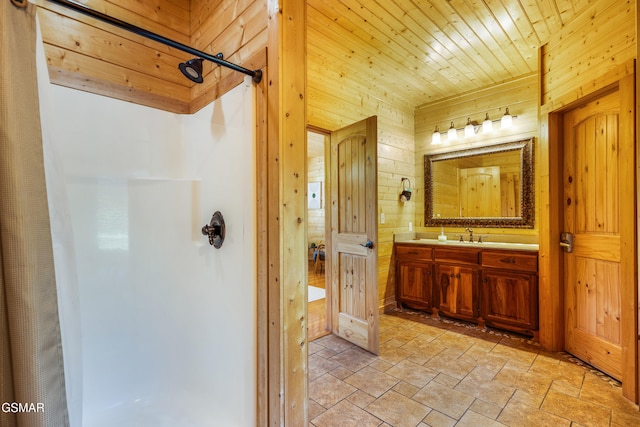 3391 Clear Valley Dr, Sevierville, TN 37862 - full bathroom featuring curtained shower, wood walls, vanity, and stone tile flooring