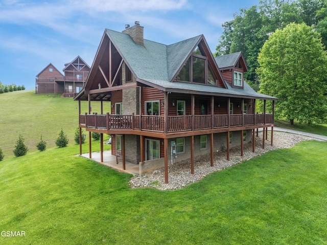 3391 Clear Valley Dr, Sevierville, TN 37862 - back of house featuring a lawn, a patio area, stone siding, a wooden deck, and a chimney