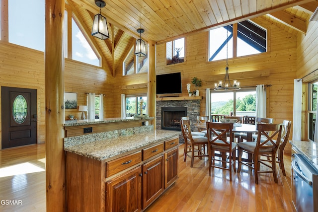 3391 Clear Valley Dr, Sevierville, TN 37862 - kitchen with high vaulted ceiling, stainless steel dishwasher, a fireplace, a wooden ceiling with exposed beams, and light stone counters