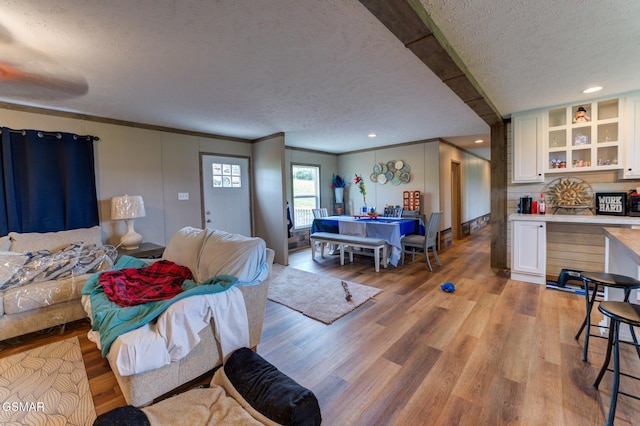 living area with a textured ceiling and light wood-style floors