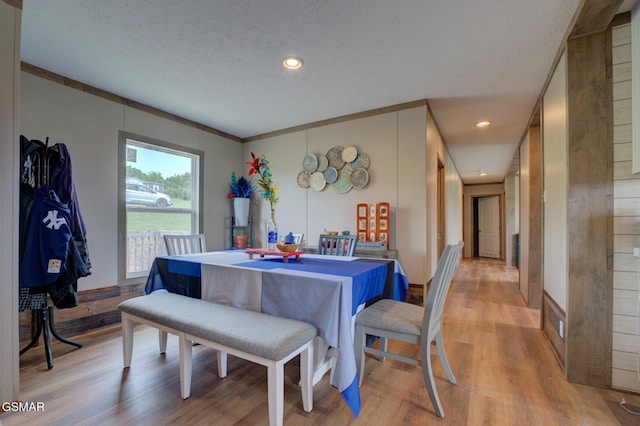 dining area featuring light wood-style floors, a textured ceiling, and recessed lighting