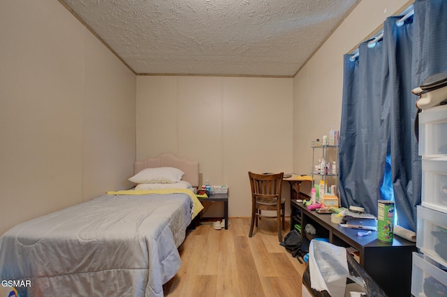 bedroom with wood finished floors and a textured ceiling