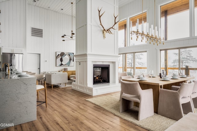 2931 Redtail Rd, Sevierville, TN 37862 - dining area featuring a healthy amount of sunlight, wood finished floors, a towering ceiling, and a multi sided fireplace