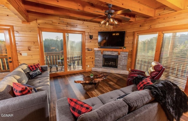 living room with a fireplace, beam ceiling, plenty of natural light, and ceiling fan