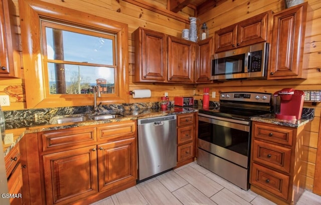 kitchen with stainless steel appliances, dark stone counters, and sink