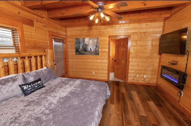 bedroom with beam ceiling, wooden walls, ceiling fan, and dark hardwood / wood-style floors