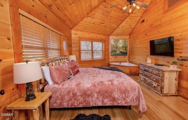 bedroom with light hardwood / wood-style floors, wooden walls, and wood ceiling