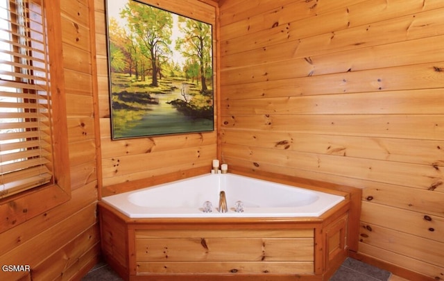 bathroom featuring wood walls and a bathtub