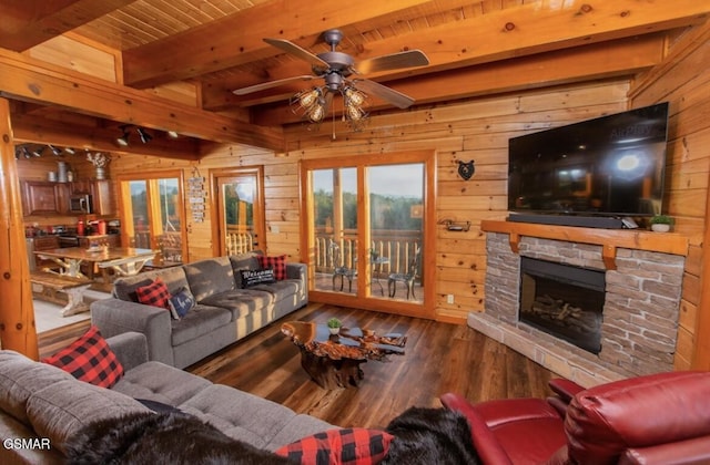 living room with beam ceiling, wood walls, ceiling fan, and hardwood / wood-style flooring