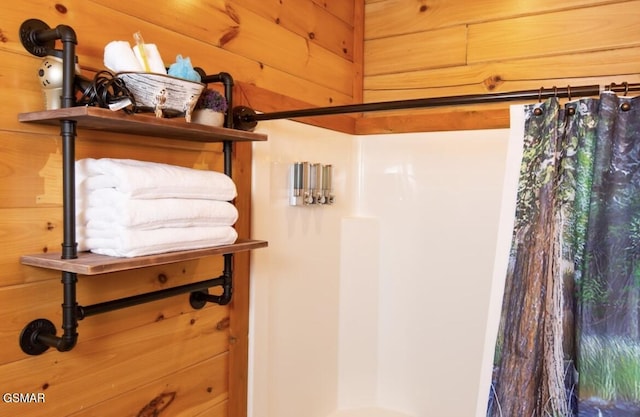 bathroom with wooden walls and a shower with shower curtain