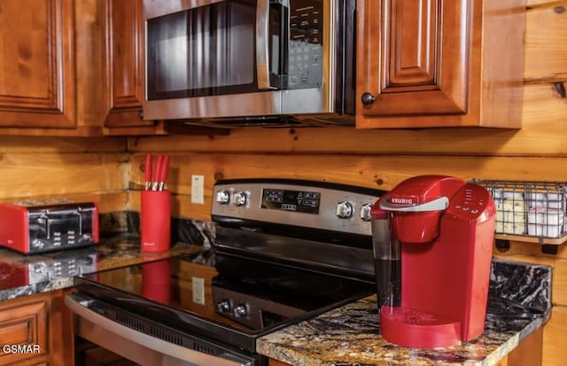 kitchen featuring dark stone counters and stainless steel appliances