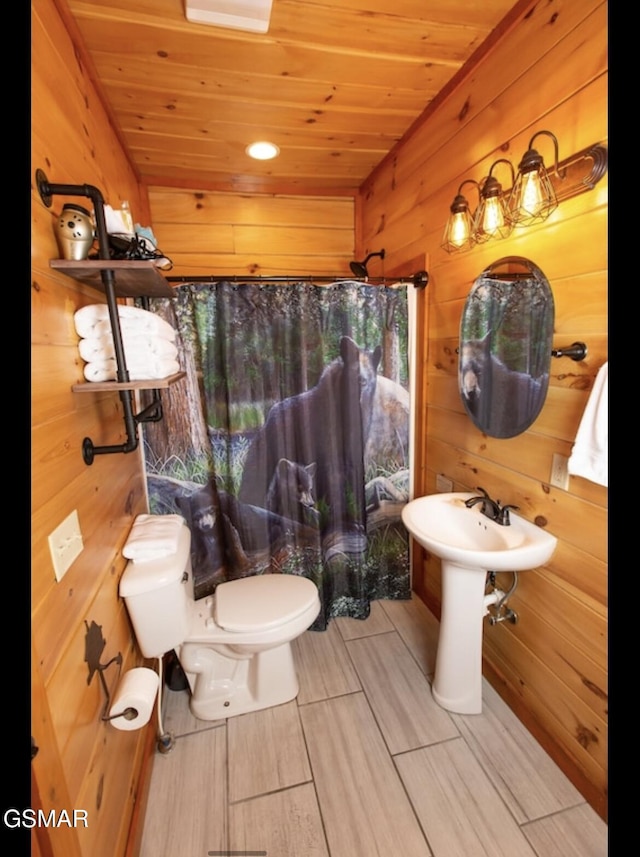 bathroom with curtained shower, wood ceiling, wood walls, and toilet