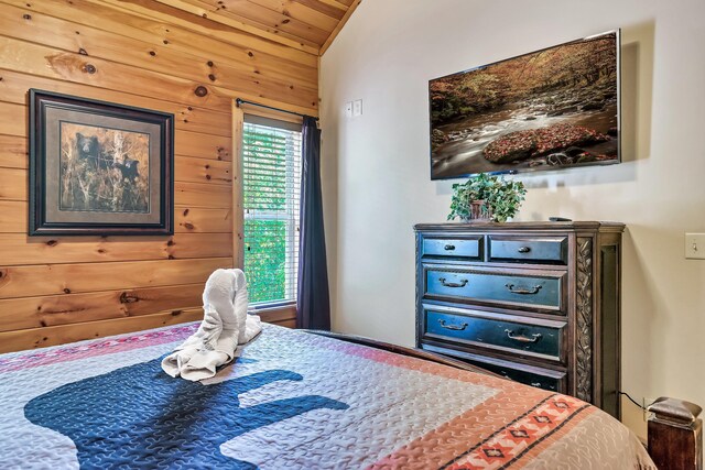 bedroom featuring wooden walls and vaulted ceiling