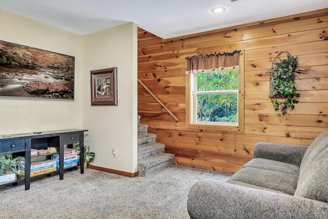 living area featuring wood walls and carpet floors