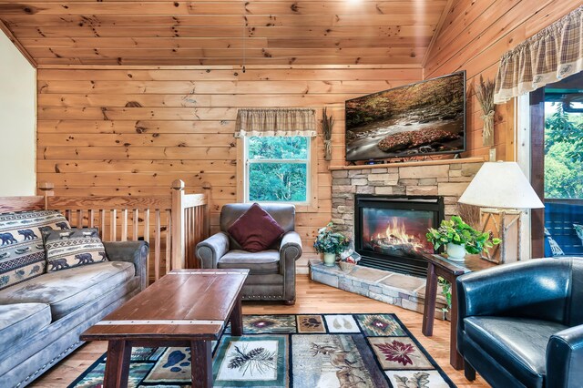 living room with wooden walls, plenty of natural light, lofted ceiling, and wood ceiling