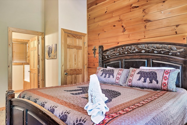 carpeted bedroom featuring wooden walls