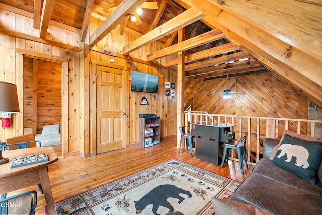 interior space with wooden walls, lofted ceiling with beams, and hardwood / wood-style flooring