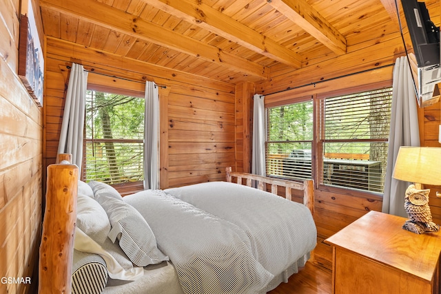 bedroom featuring wooden walls, beamed ceiling, wood ceiling, and multiple windows