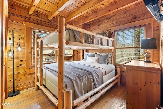 bedroom featuring hardwood / wood-style floors, beam ceiling, wood ceiling, and wood walls