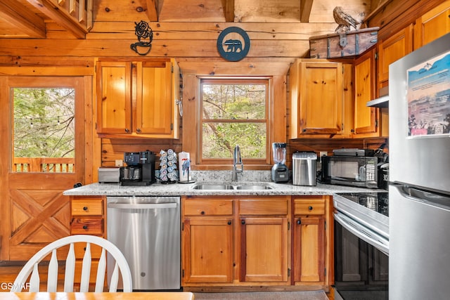 kitchen featuring a sink, light stone counters, brown cabinets, and stainless steel appliances