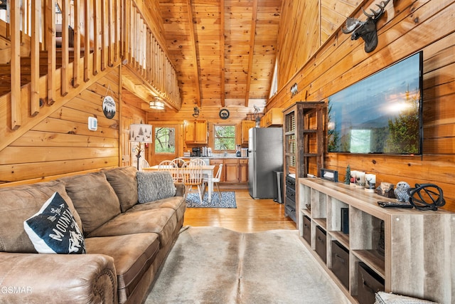 living room featuring wooden ceiling, wooden walls, light wood-type flooring, and high vaulted ceiling