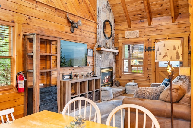 living room featuring a stone fireplace, wooden ceiling, wooden walls, and lofted ceiling with beams