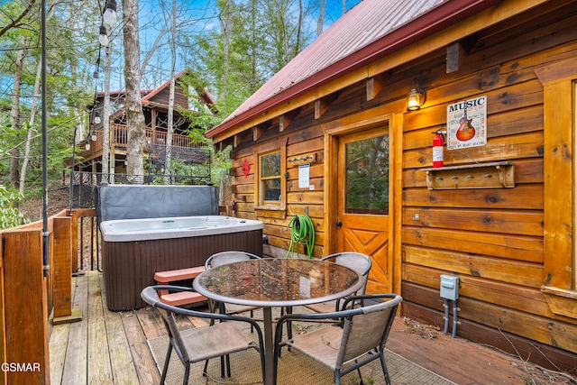 wooden terrace with central AC, outdoor dining space, and a hot tub