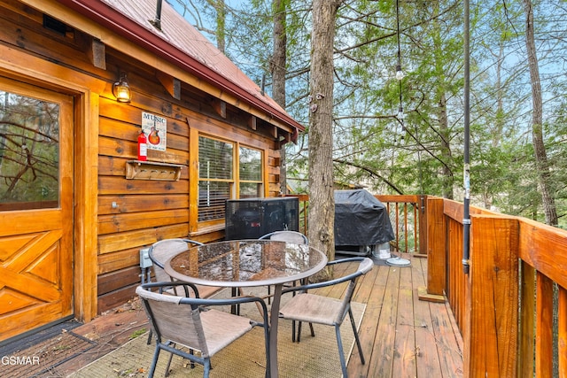 wooden terrace with outdoor dining space and grilling area