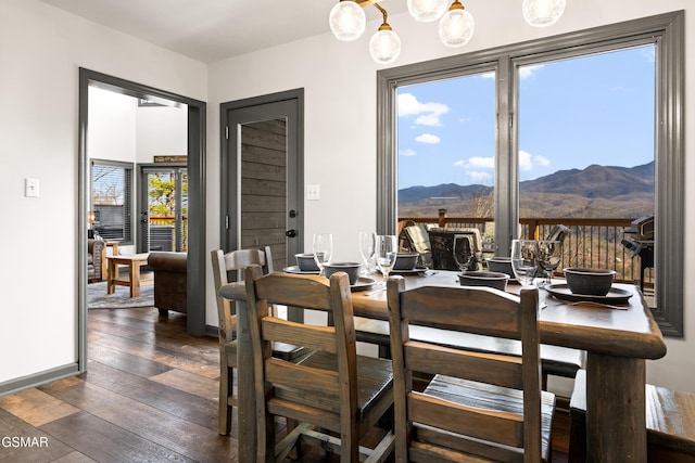 dining space with dark wood finished floors, a mountain view, and baseboards