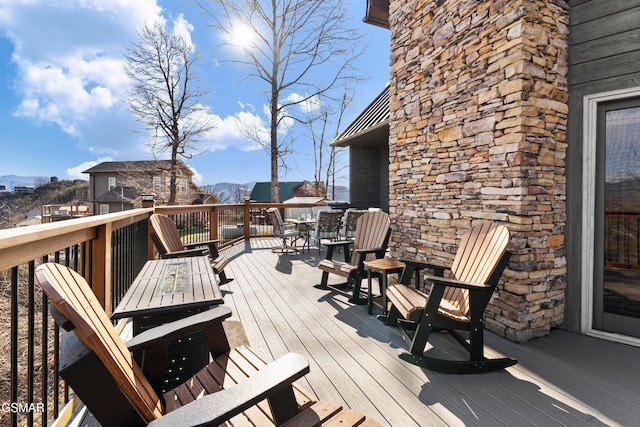 deck featuring a mountain view and outdoor dining area