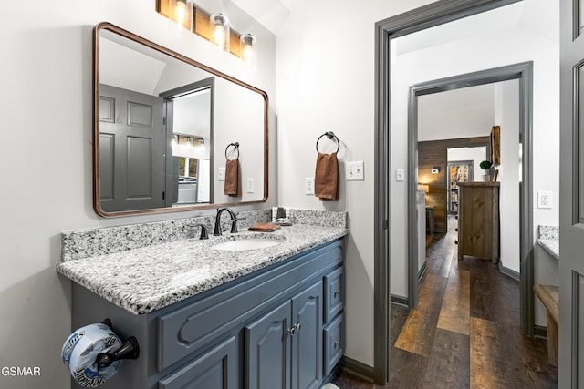 bathroom with hardwood / wood-style floors, vanity, and baseboards