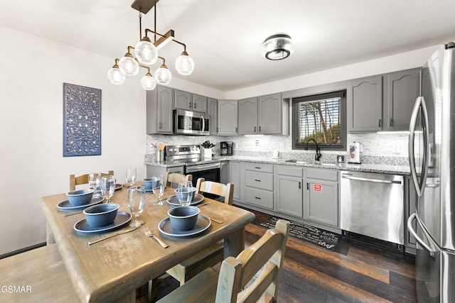 kitchen featuring a sink, appliances with stainless steel finishes, gray cabinets, and decorative backsplash