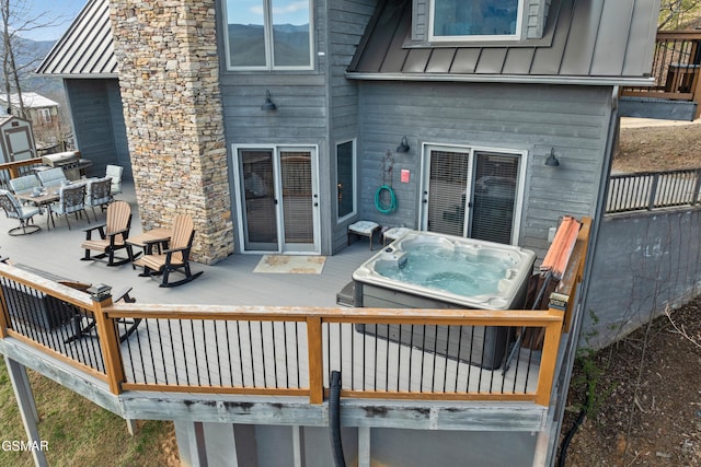 back of property featuring a hot tub, a deck, and board and batten siding