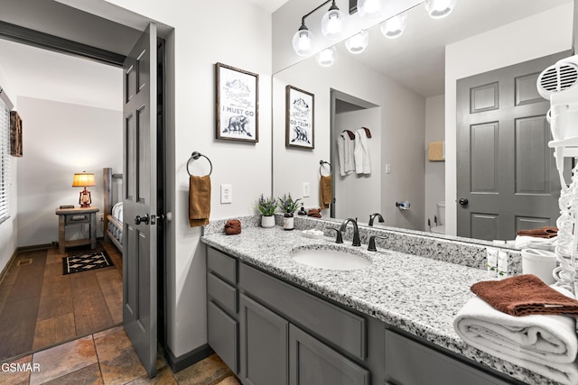 bathroom with toilet, vanity, and baseboards