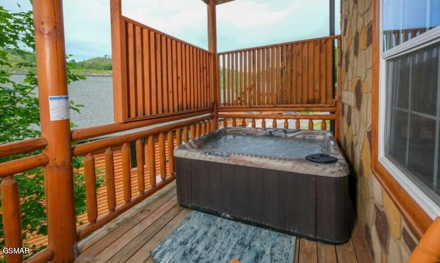 deck featuring a water view and a hot tub