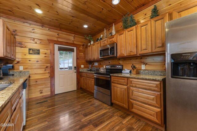 kitchen with wood walls, wooden ceiling, light stone counters, appliances with stainless steel finishes, and dark hardwood / wood-style flooring