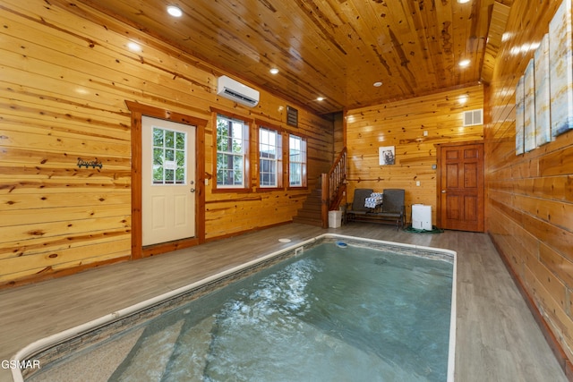 view of swimming pool with an AC wall unit and a jacuzzi