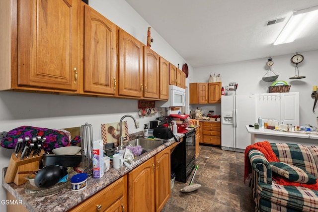 kitchen featuring brown cabinets, a sink, stone finish flooring, white microwave, and black range with electric cooktop