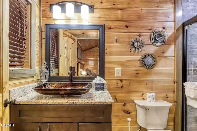 half bathroom with vanity, wooden walls, and toilet