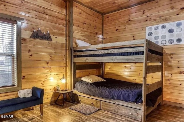 bedroom with wood walls, wooden ceiling, and wood finished floors