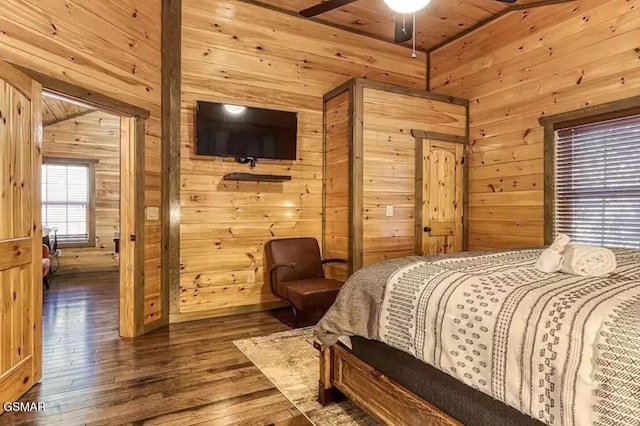 bedroom featuring wooden walls, lofted ceiling, and hardwood / wood-style floors