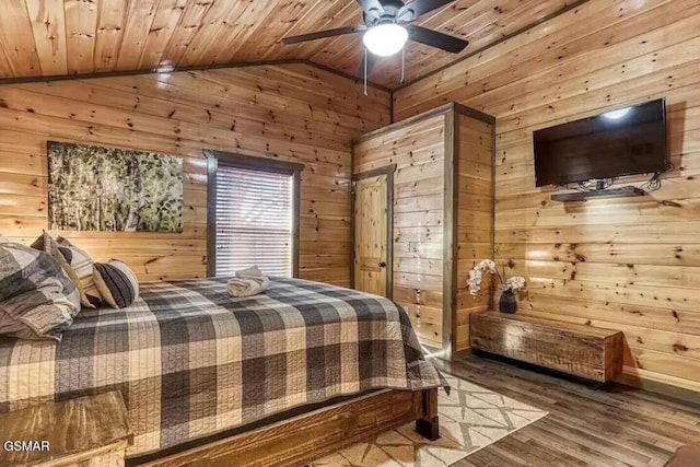 bedroom featuring vaulted ceiling, wooden walls, wood finished floors, and wooden ceiling