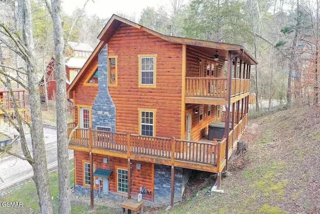 rear view of house featuring a deck and faux log siding