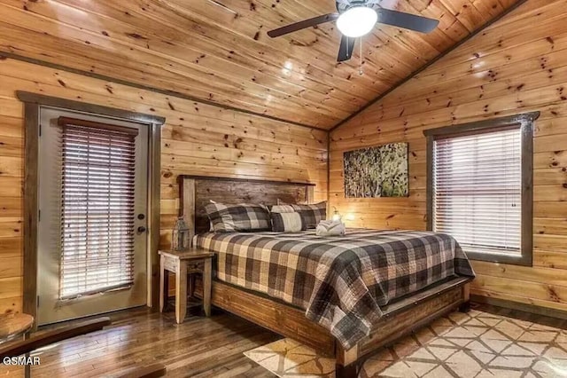 bedroom with multiple windows, wood ceiling, wood walls, and vaulted ceiling