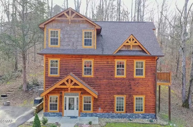 log home with faux log siding and a patio area